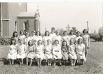 Group Photo of 21 Girls and Women outside Chapel by Sisters of the Good Shepherd