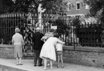 Pilgrims on the sidewalk, facing the statue, 1960