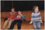 Three children sitting on a couch at the Caritas Program