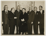 group of people standing while woman poses for picture