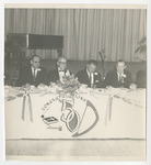 4 men seated at a table for a 50 year celebration