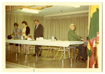Several people standing around a table.