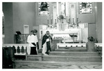 Priest walks in front of altar