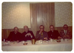 Five men eating at a table
